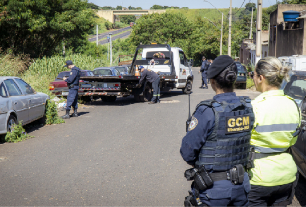 Operação de remoção de veículos irregulares com agentes da GCM em área urbana.