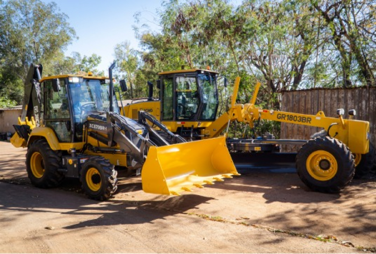 Máquinas pesadas XCMG e GR1803BR usadas para escavação e nivelamento em obras de construção.