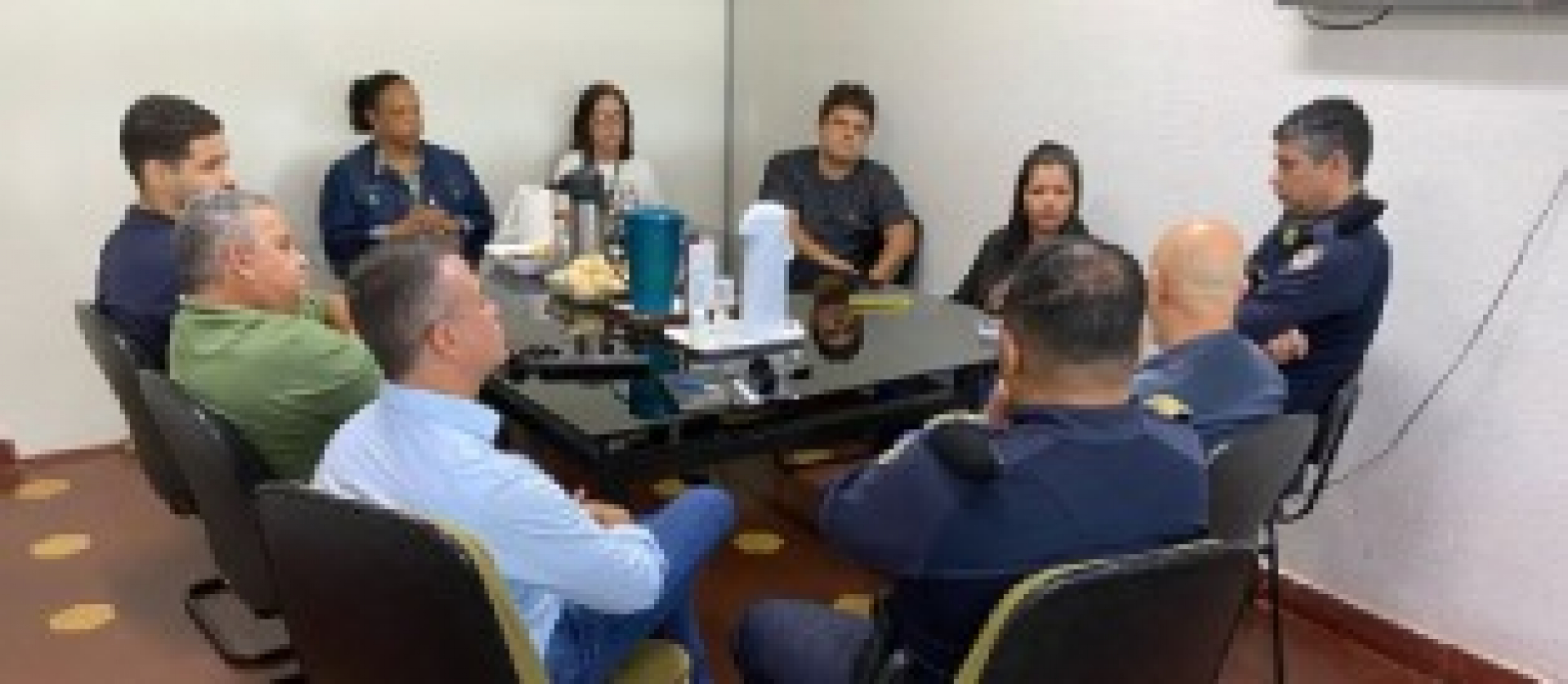 Reunião entre representantes da guarda municipal e gestores ocorre em sala fechada.