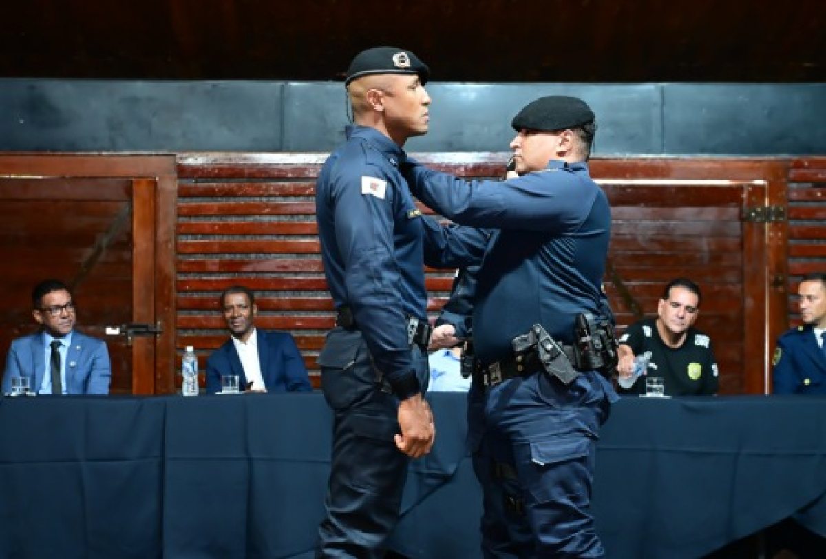Agente recebe insígnia no uniforme durante cerimônia oficial.
