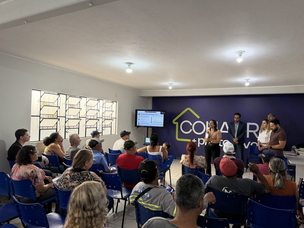 Reunião comunitária reúne moradores e representantes para apresentar projetos habitacionais e discutir melhorias na comunidade.