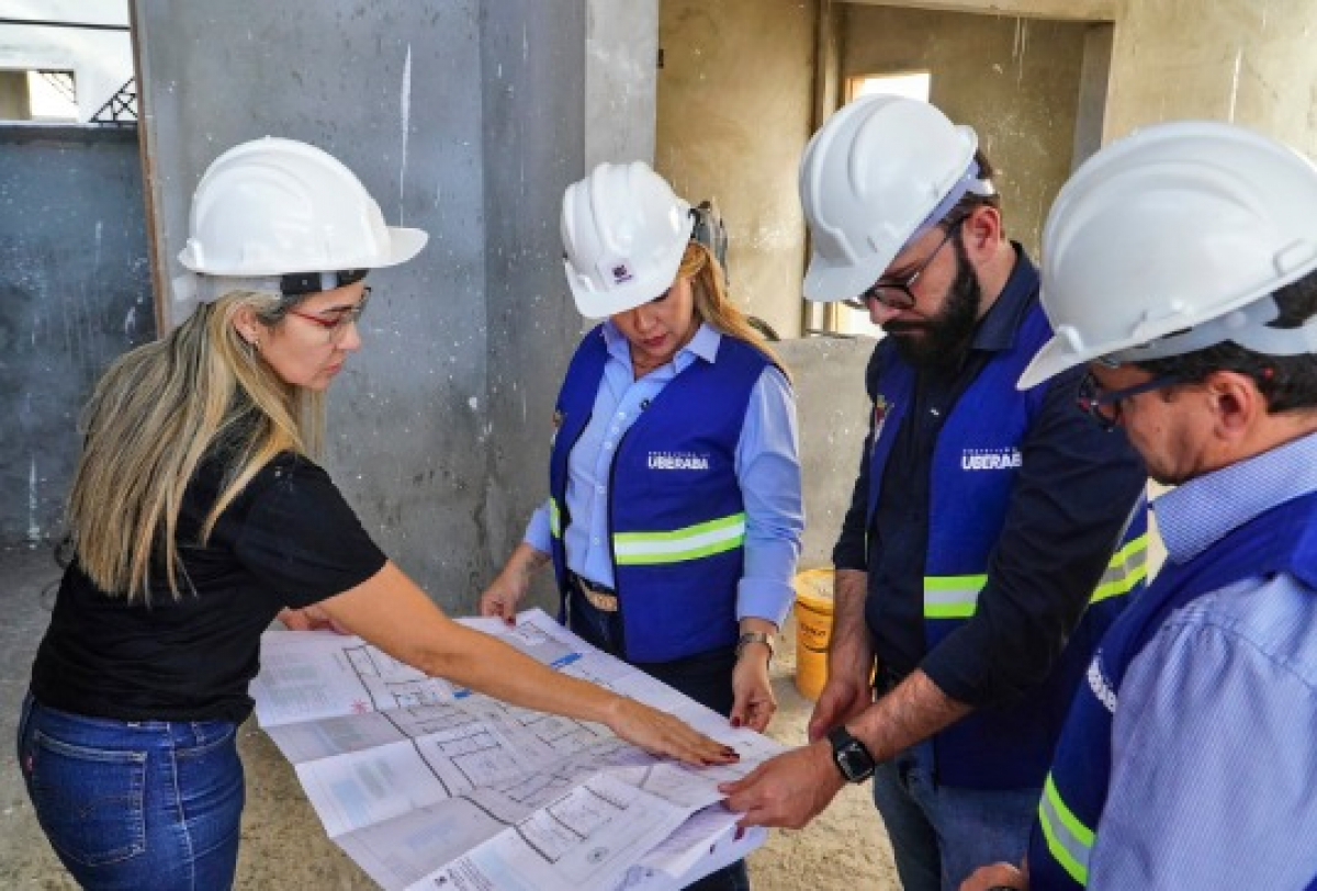 Equipe técnica da Prefeitura de Uberaba analisa planta durante vistoria em obra pública.