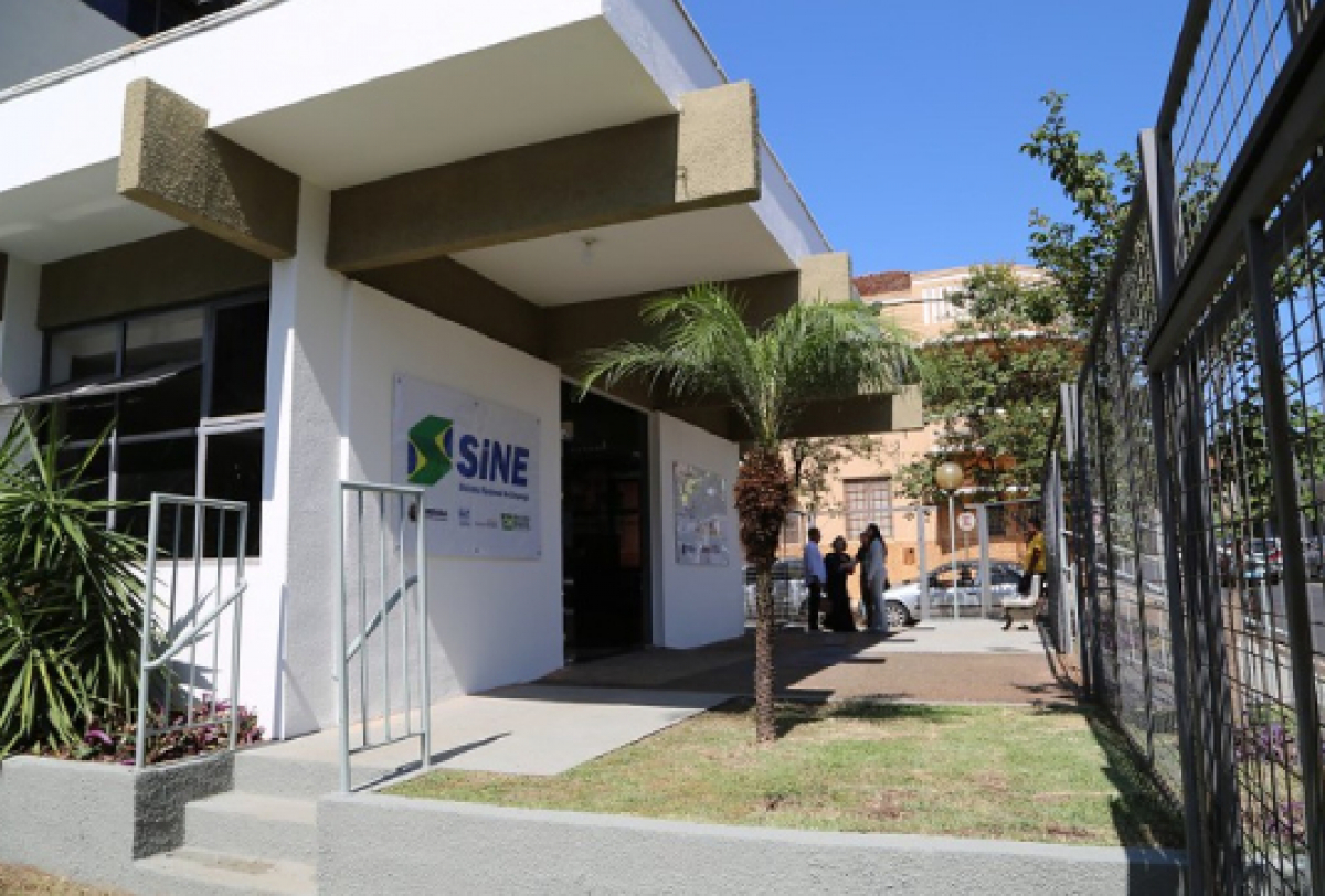 Fachada do posto do SINE com entrada acessível e pessoas em frente ao prédio em área urbana.