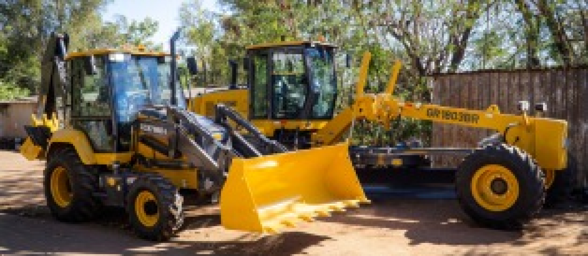 Máquinas pesadas XCMG e GR1803BR usadas para escavação e nivelamento em obras de construção.