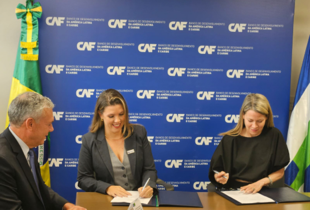 Assinatura de acordo oficial entre representantes no evento do Banco de Desenvolvimento da América Latina (CAF).