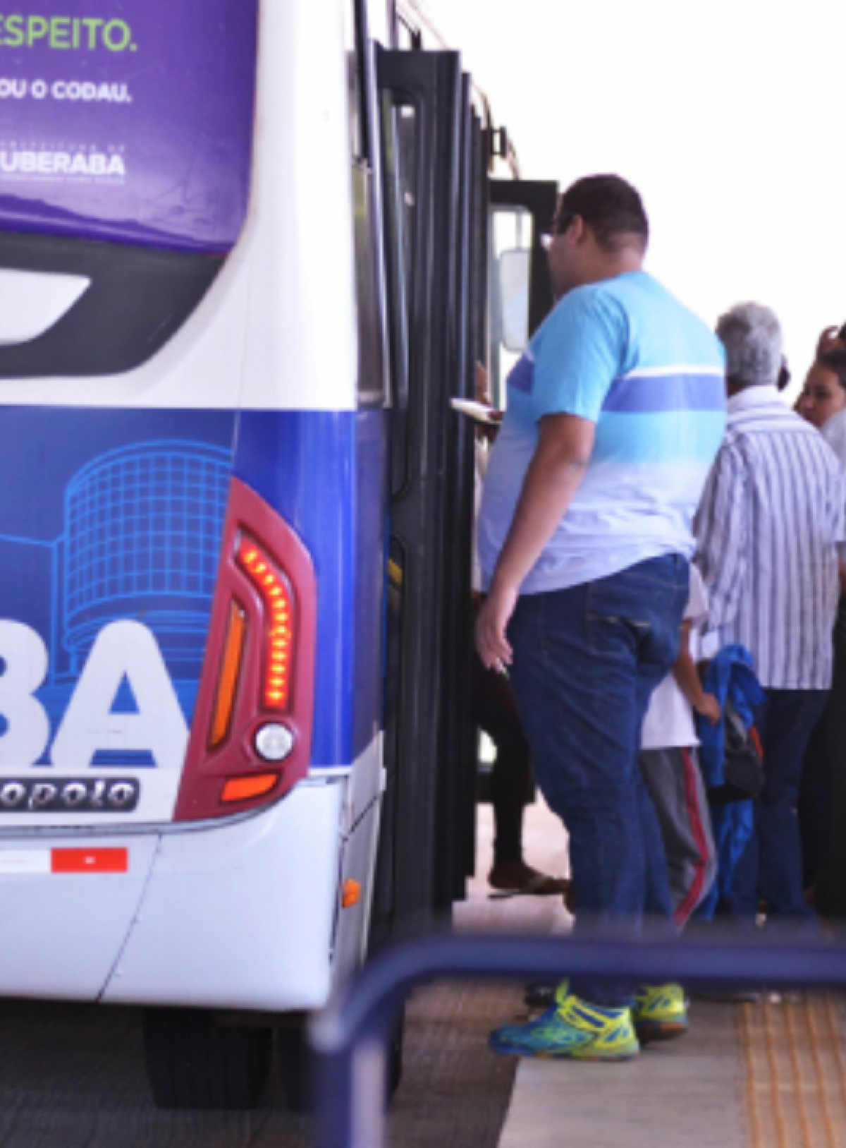 A imagem mostra pessoas embarcando em um ônibus coletivo em Uberaba,  com Marcopolo visível na traseira do veículo.