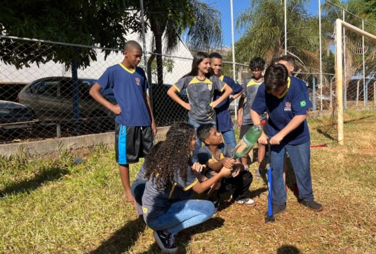 Estudantes participam de atividade prática ao ar livre com lançamento de foguete feito com garrafa PET.