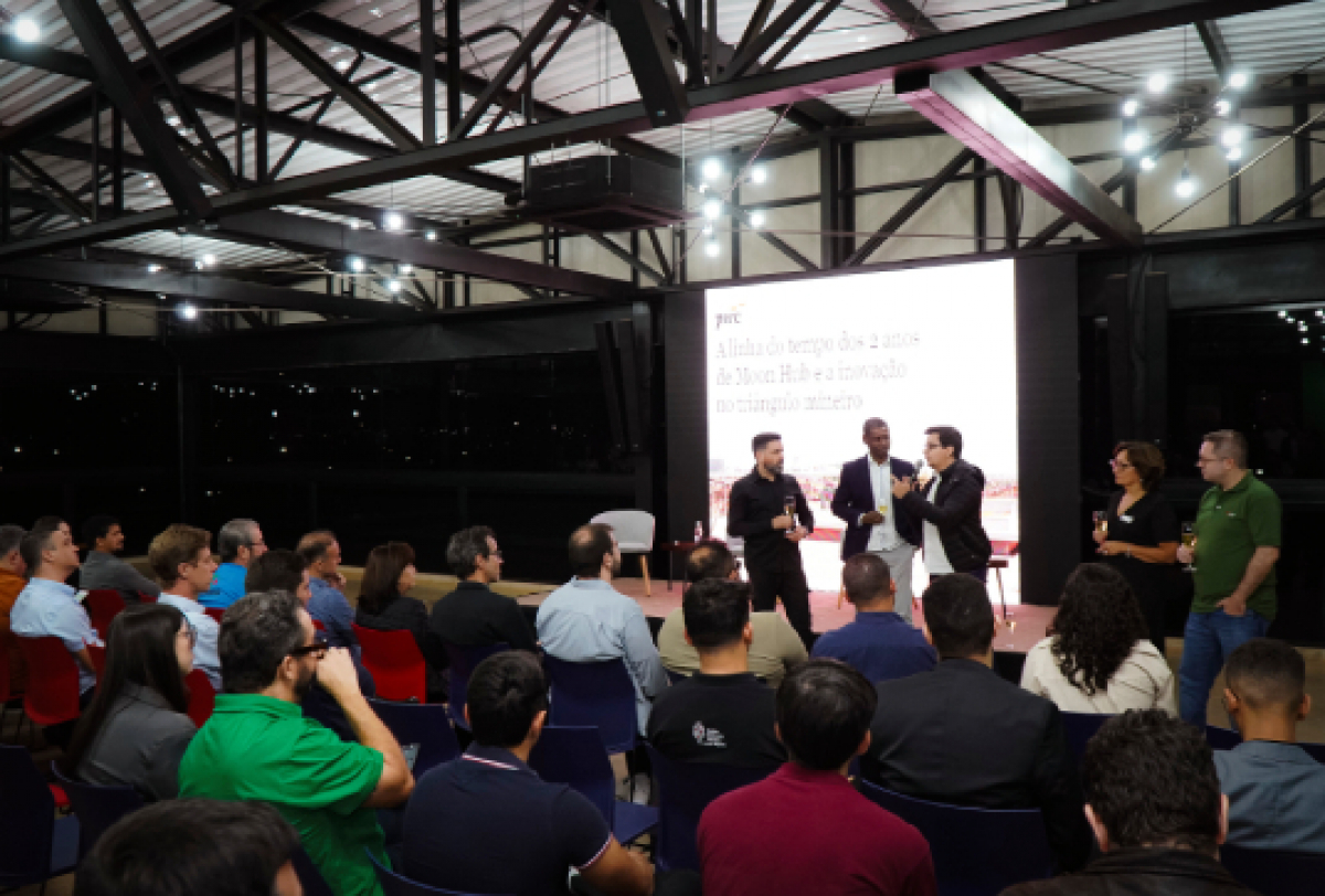 Evento corporativo da PwC reúne público para apresentação e debate em ambiente moderno. 