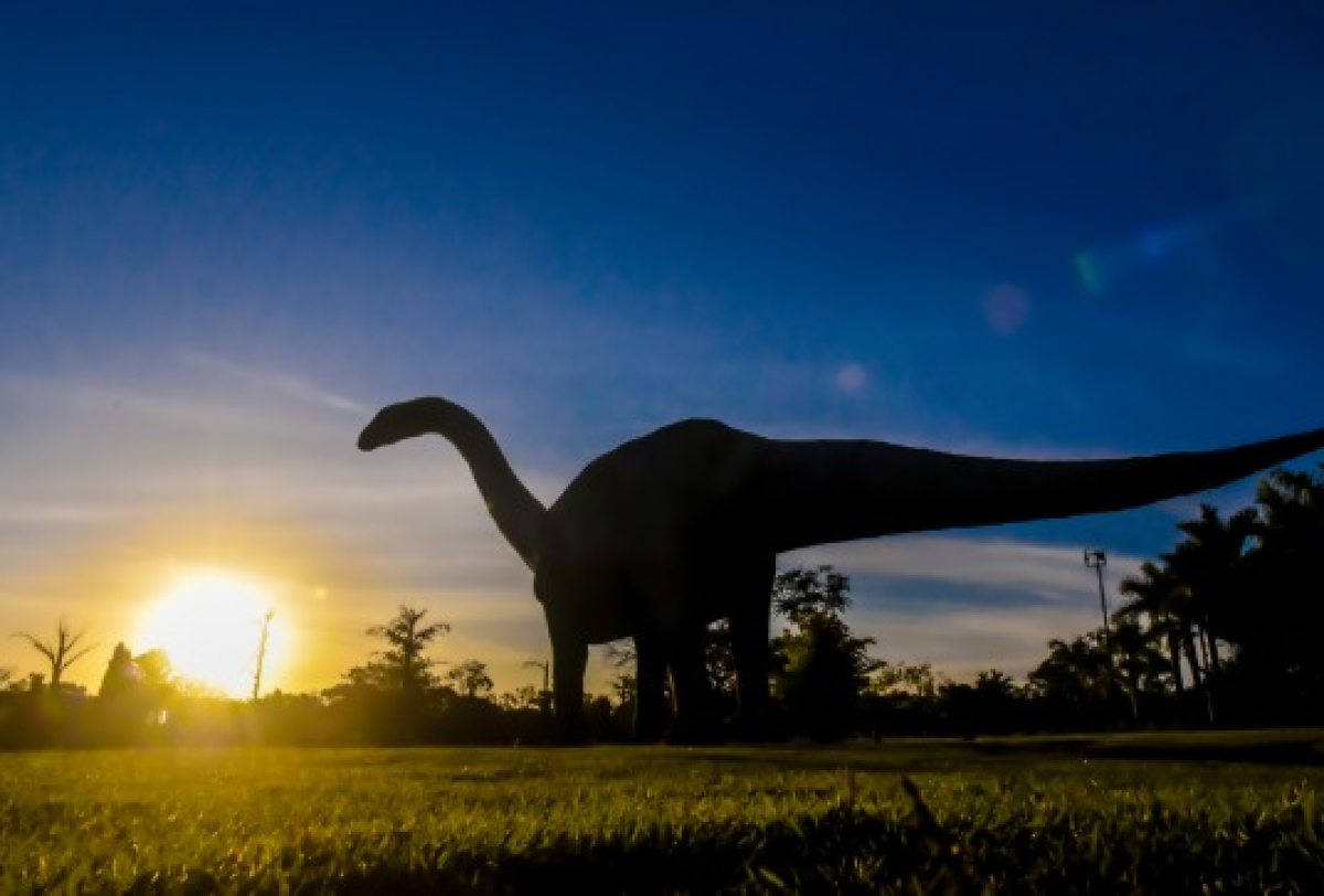Silhueta de dinossauro em Peirópolis, Uberaba, durante o pôr do sol.