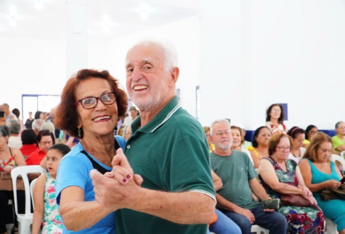 Idosos dançando juntos em um evento comunitário, celebrando alegria, saúde e conexão social.