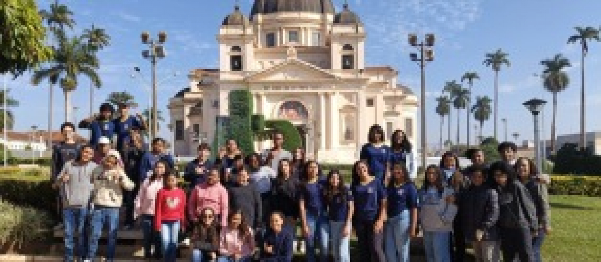 Grupo de estudantes posa em frente à Igreja Matriz do Senhor Bom Jesus da Cana Verde em uma visita cultural.