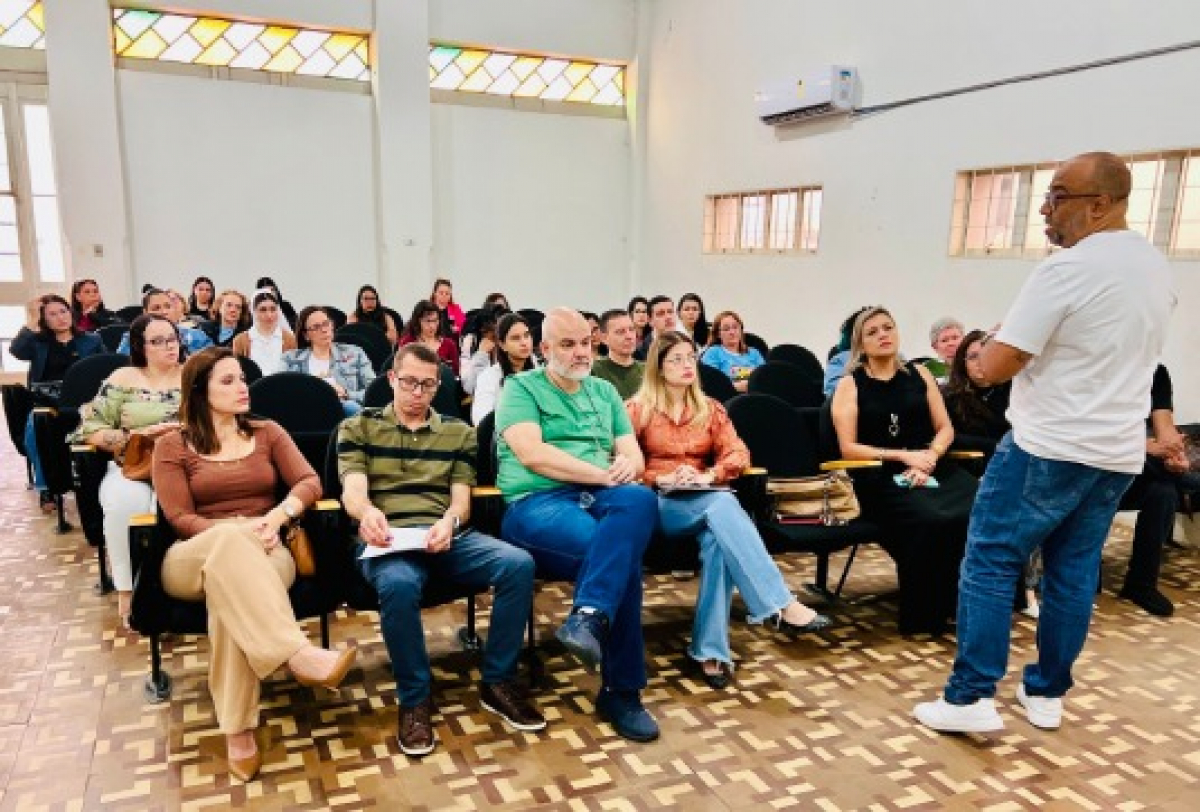 Um evento em um ambiente clássico, com público atento e envolvido em uma discussão produtiva.