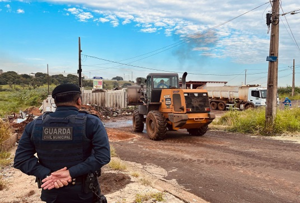 Guarda Civil Municipal acompanha operação de limpeza com máquinas pesadas em área urbana.