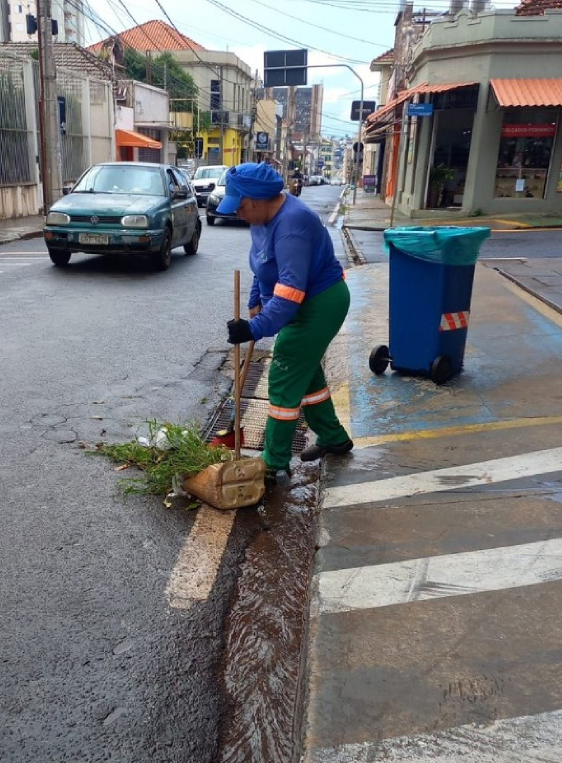 Trabalhadora da limpeza urbana realiza varrição de rua em área central de Uberaba.