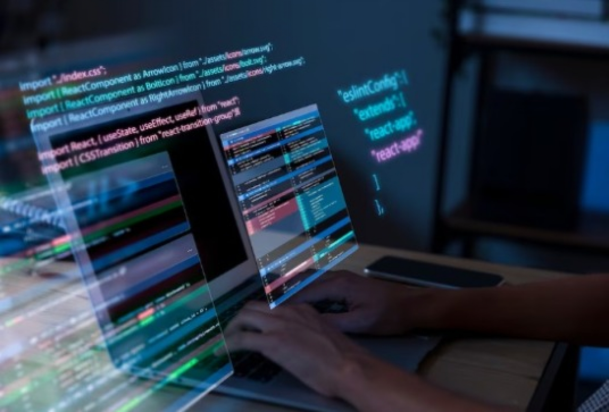 A imagem mostra uma pessoa programando em React com código projetado digitalmente em 3D ao redor do laptop.