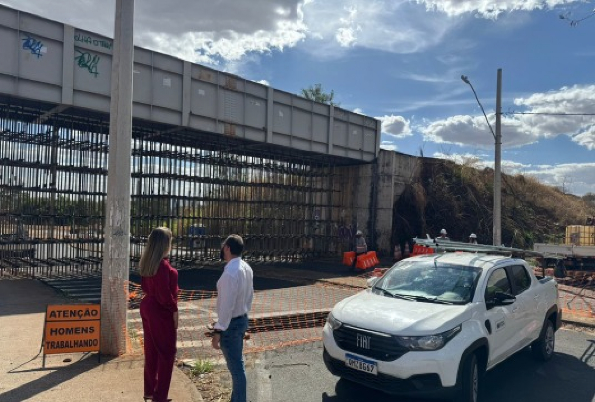 Obras de manutenção são realizadas sob um viaduto ferroviário com parte da via interditada.