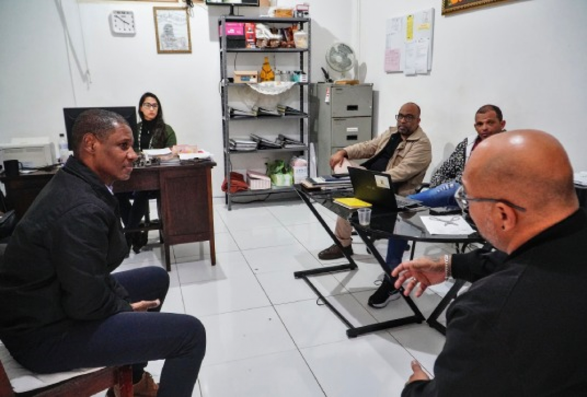 Reunião de trabalho em escritório com foco em planejamento e troca de ideias entre equipe.