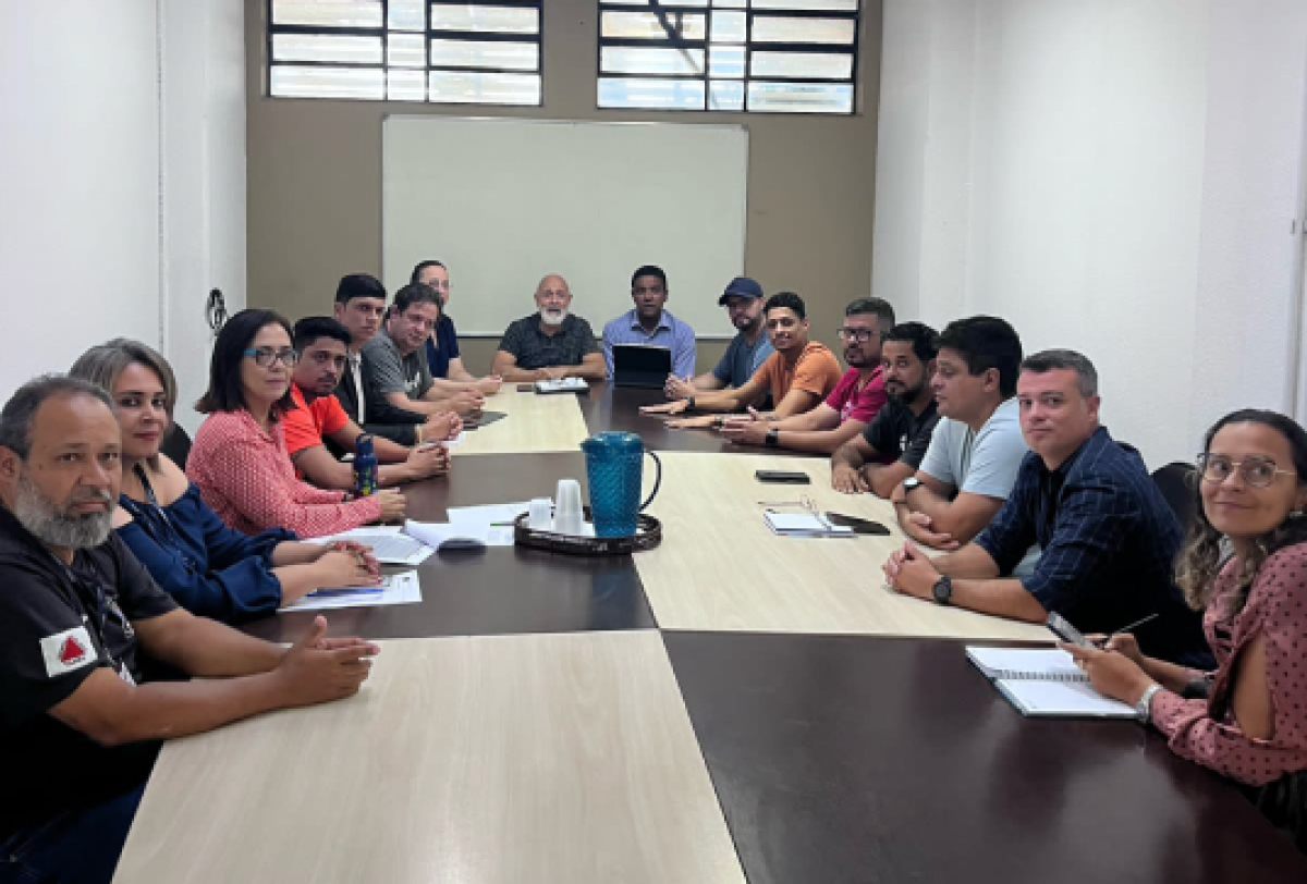 Reunião entre representantes do setor de transporte por aplicativo e equipe da Defesa Social em uma sala de reuniões formal.