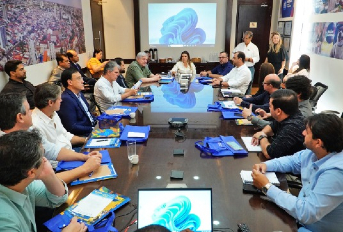 Reunião com diversos gestores discutindo projetos em uma sala de conferências.