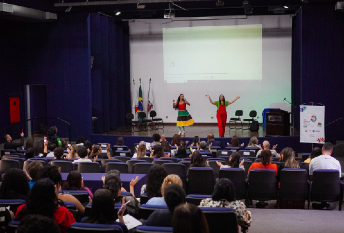 Apresentações artísticas e palestras marcaram um dia de evento em auditório com foco educativo e cultural, reunindo grande público.  