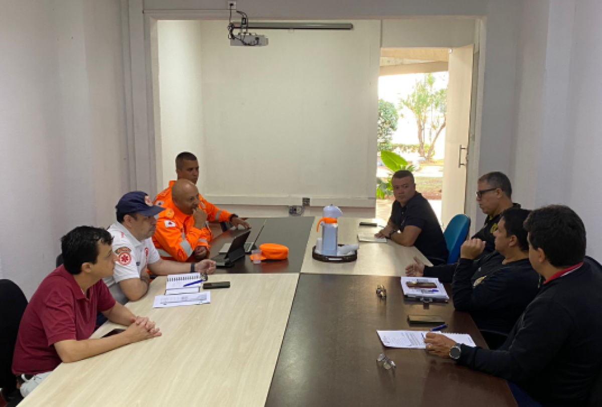 Reunião entre equipes de emergência e defesa civil para planejamento de ações.