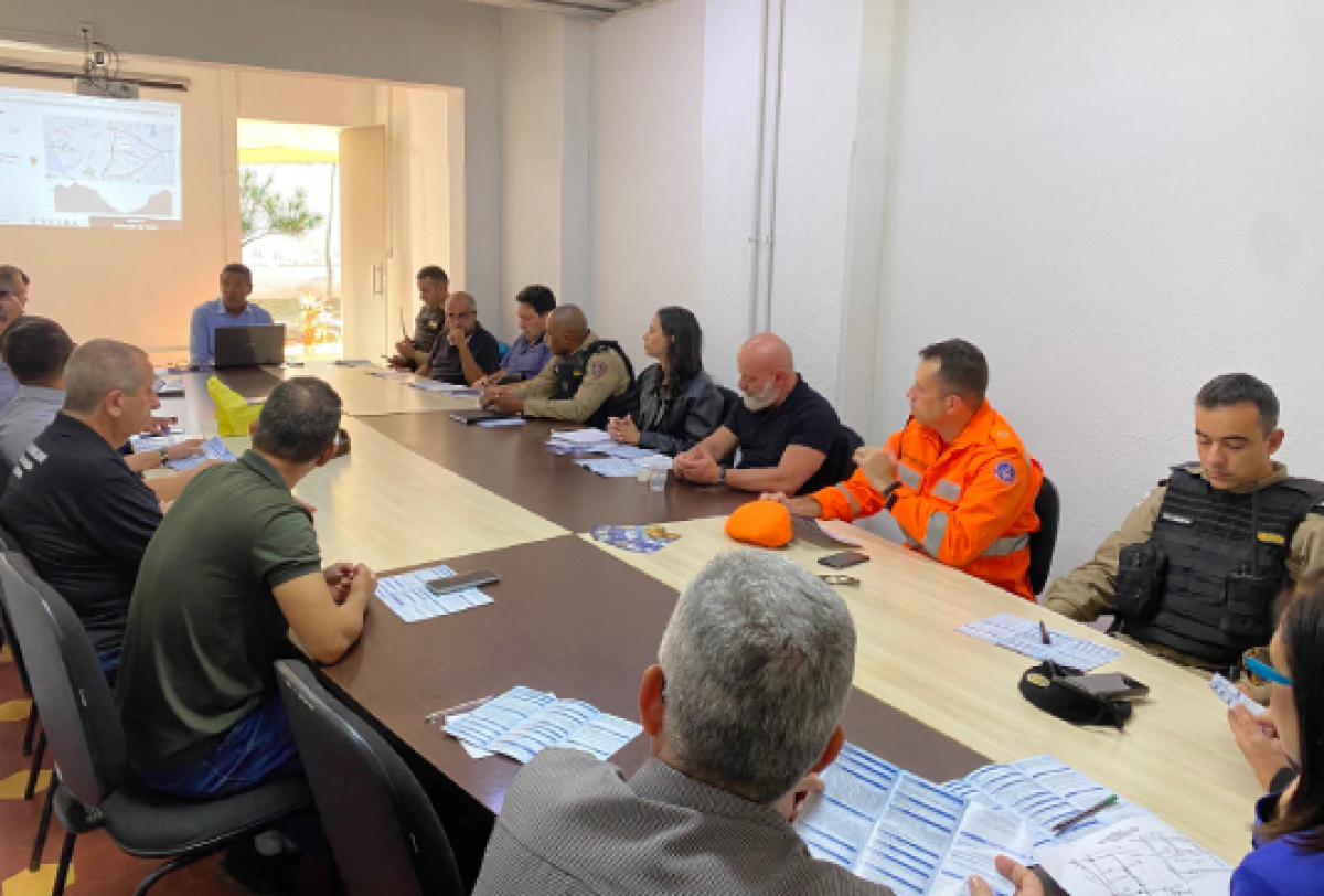 Reunião de um dia com forças de segurança e defesa civil para planejar ações integradas, com uso de mapas e materiais estratégicos.