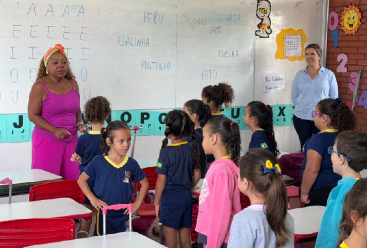 Uma professora ensina palavras e nomes de animais a alunos atentos em uma sala de aula animada.