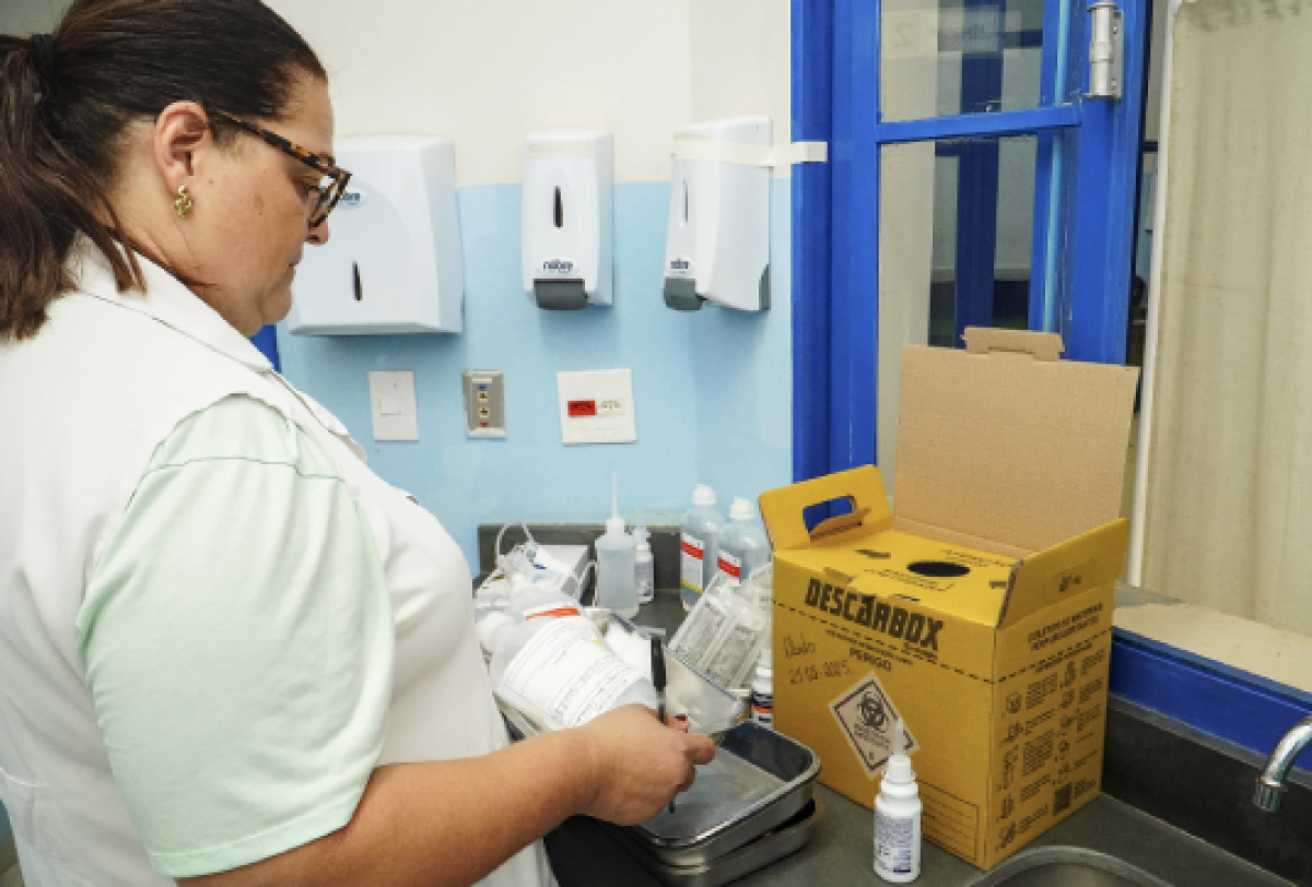 A imagem mostra um ambiente médico focado em segurança e higiene,  e suprimentos de descarte apropriados.