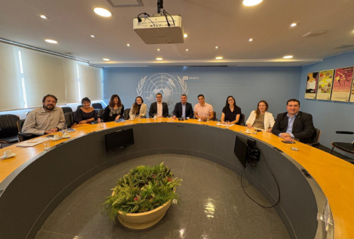 Um grupo de pessoas participa de uma reunião em uma sala.