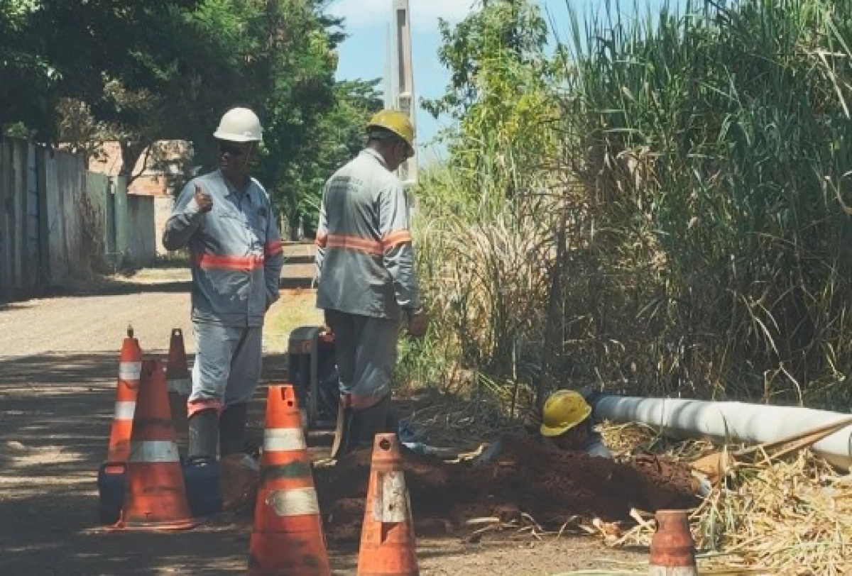 Dois trabalhadores em um ambiente ao ar livre realizando uma obra ou manutenção.