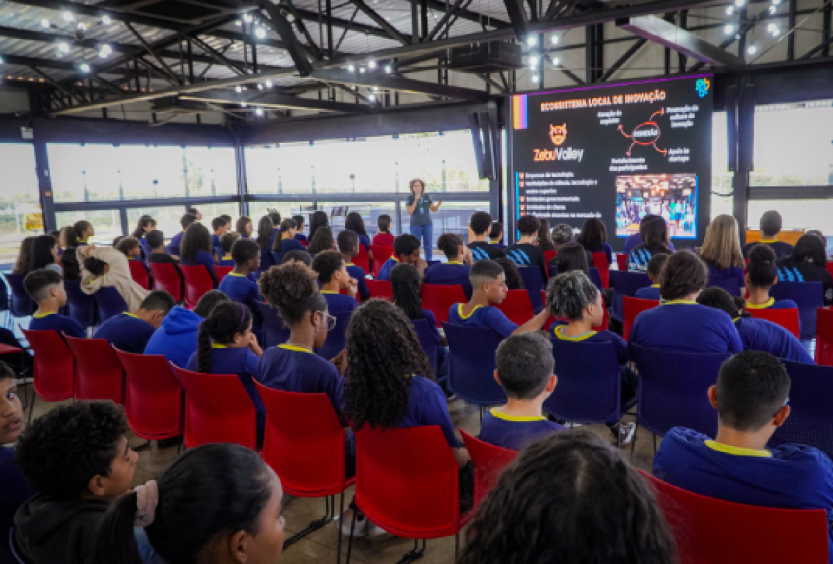 Estudantes assistem a uma palestra sobre inovação e o ecossistema do Zebu Valley em auditório moderno.