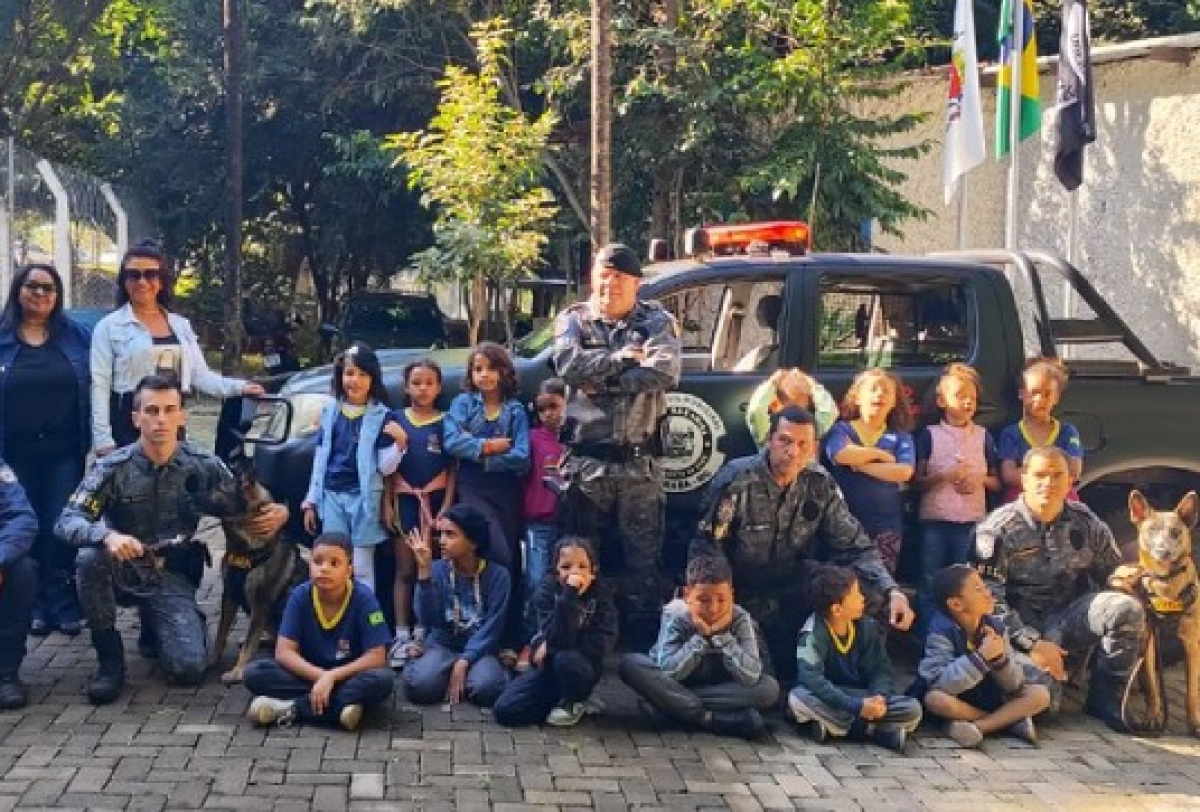 Crianças visitam a guarda municipal em uma atividade educativa com cães policiais.