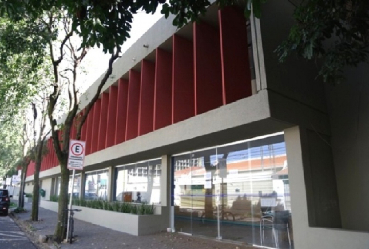 Um prédio moderno com design marcante, combinando painéis vermelhos e janelas de vidro.