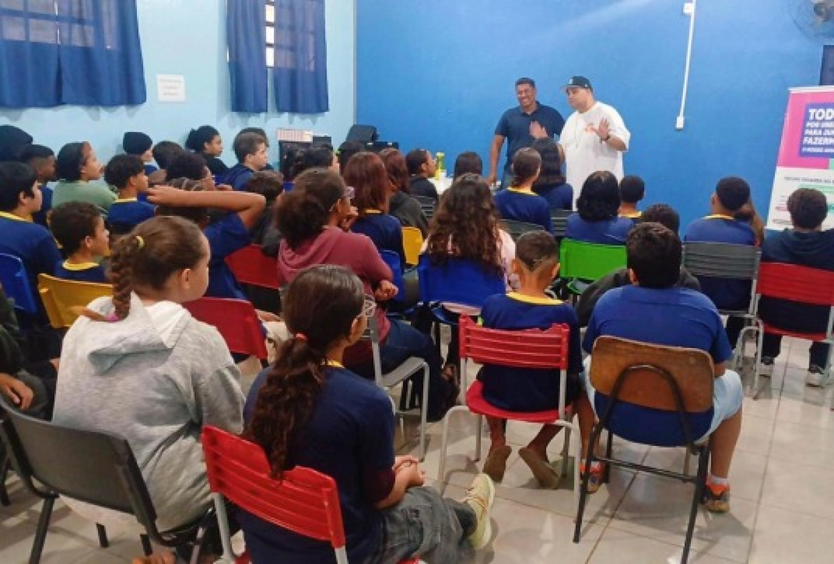 Palestra educativa sendo realizada para um grupo de estudantes em sala de aula.