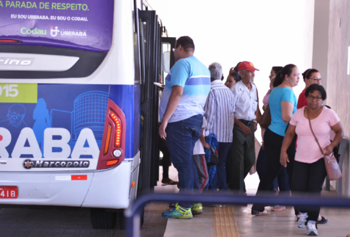 Imagem mostrando pessoas embarcando em um ônibus, com destaque para o letreiro e a lateral do veículo.