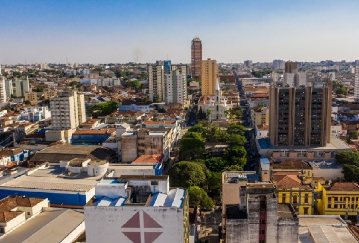 Vista aérea de uma área urbana com prédios, casas e ruas movimentadas em uma cidade.