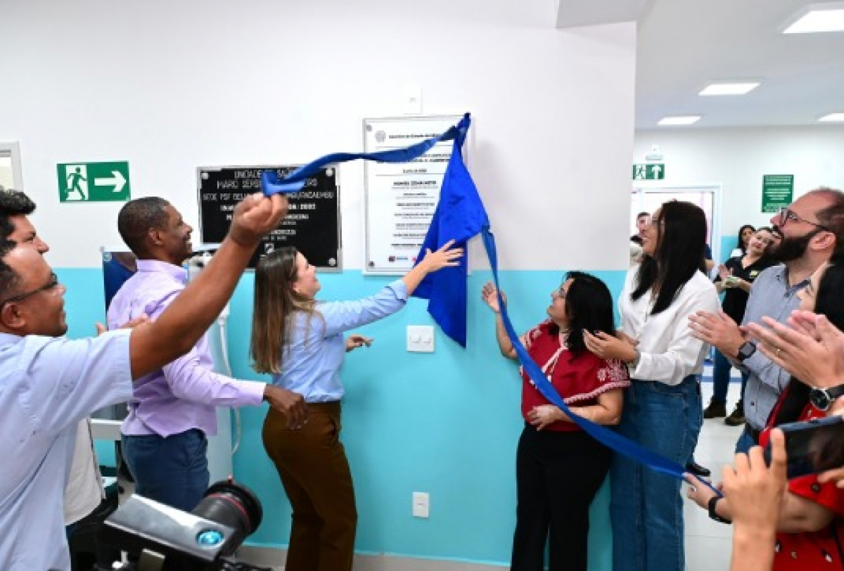 Cerimônia de inauguração de unidade de saúde com descerramento de placa por autoridades e comunidade.