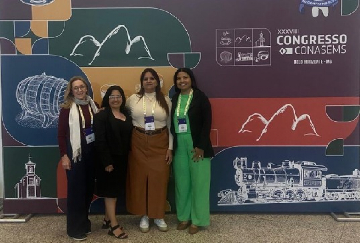 Participantes posam em frente ao painel do XXXVIII Congresso CONASEMS em Belo Horizonte.