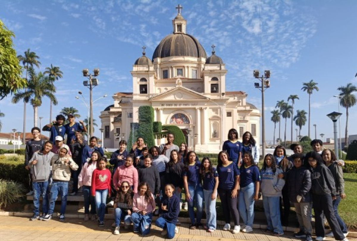 Grupo de estudantes posa em frente à Igreja Matriz do Senhor Bom Jesus da Cana Verde em uma visita cultural.
