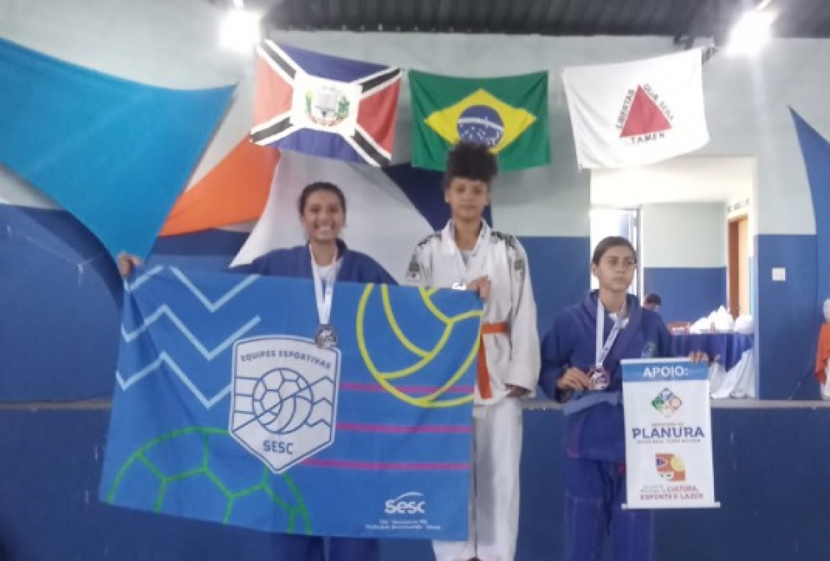 Alunos conquistam medalhas em competição de judô, com bandeiras do SESC e apoio da Prefeitura de Planura.