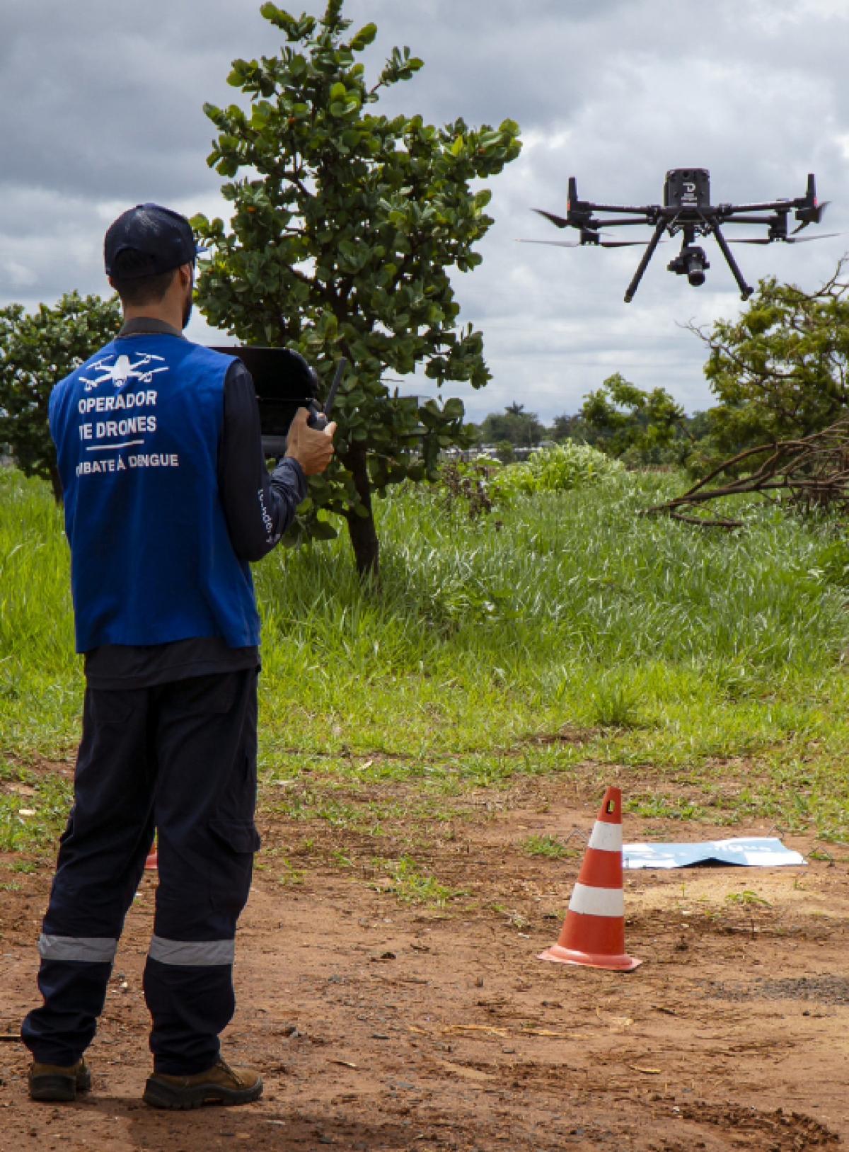 Operador de drone profissional controla um equipamento em área delimitada para voo.
