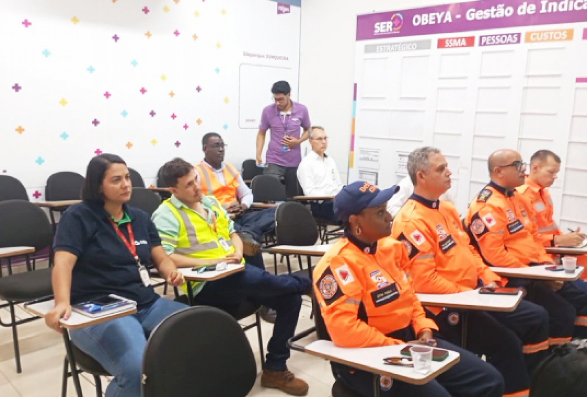 Reunião de equipe com profissionais de segurança e emergência, acompanhando indicadores de gestão.