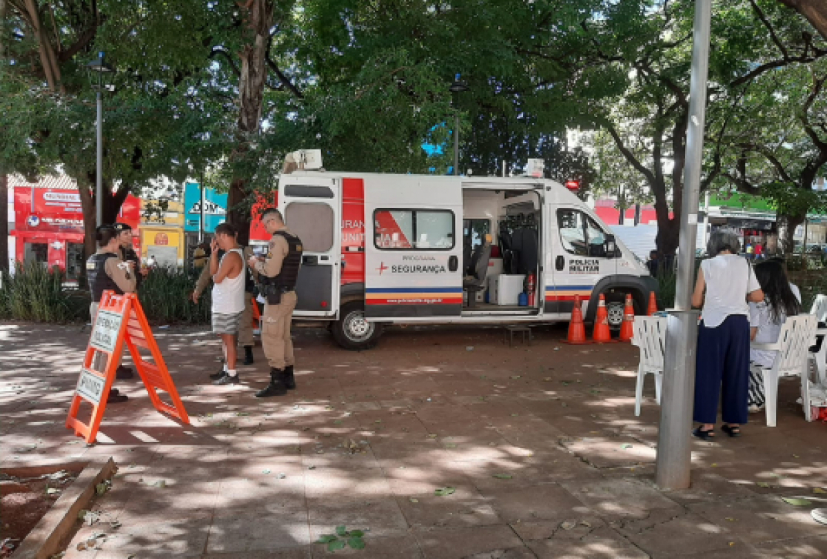 Posto móvel da Polícia Militar em uma praça, com policiais e atendimento ao público.