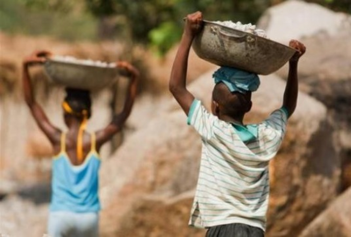 Crianças realizam trabalho pesado carregando bacias na cabeça, evidenciando uma situação de trabalho infantil.