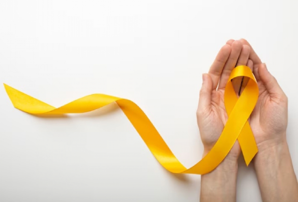 Mãos seguram um laço amarelo, símbolo da campanha Setembro Amarelo de prevenção ao suicídio.