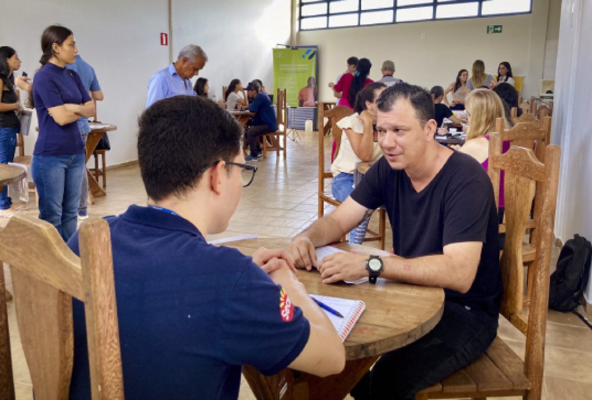 Pessoas participando de uma atividade de atendimento ou orientação em um ambiente comunitário.