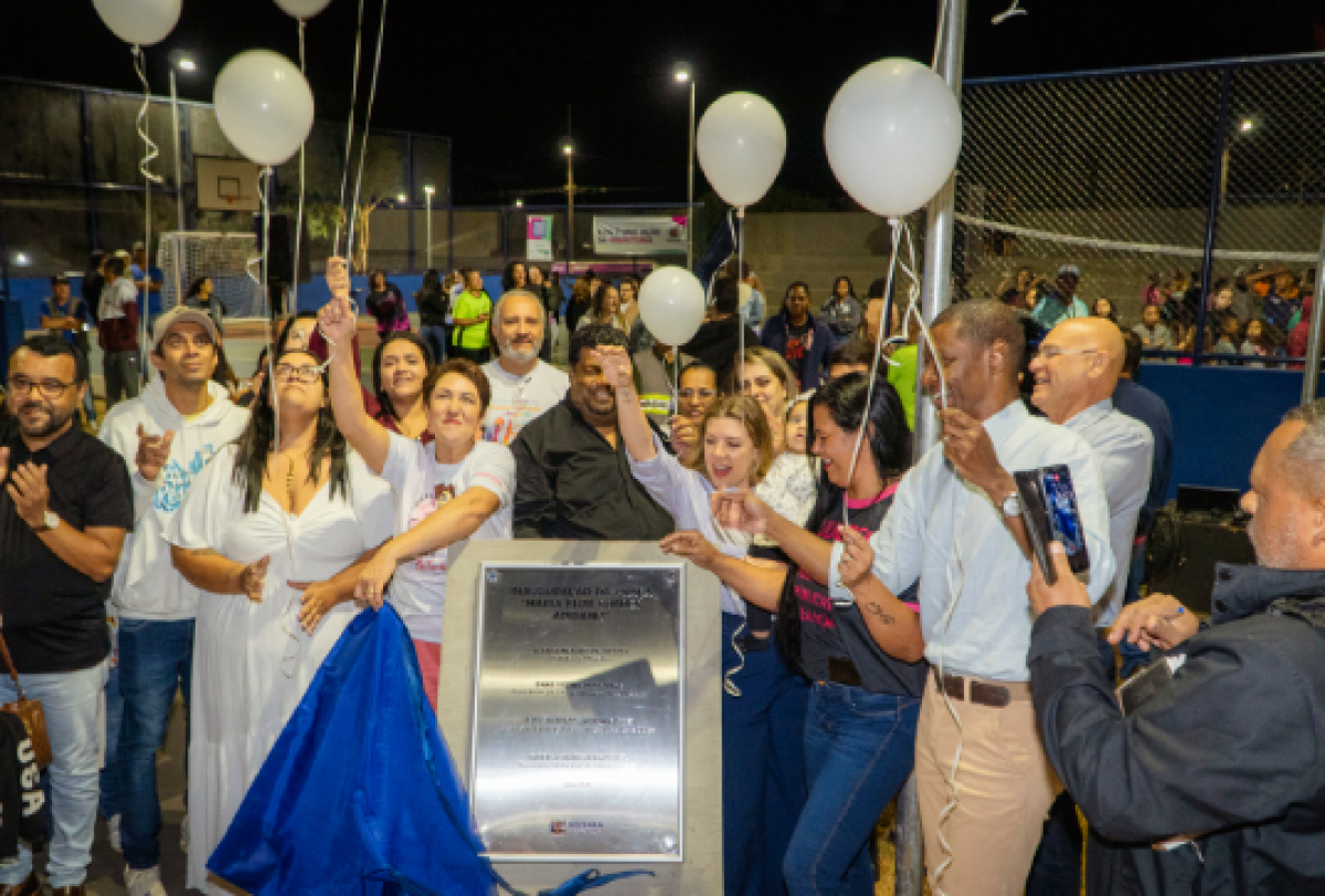Moradores e autoridades comemoram a inauguração da Praça Maria Flor Soares Adriano com balões e placa comemorativa. 