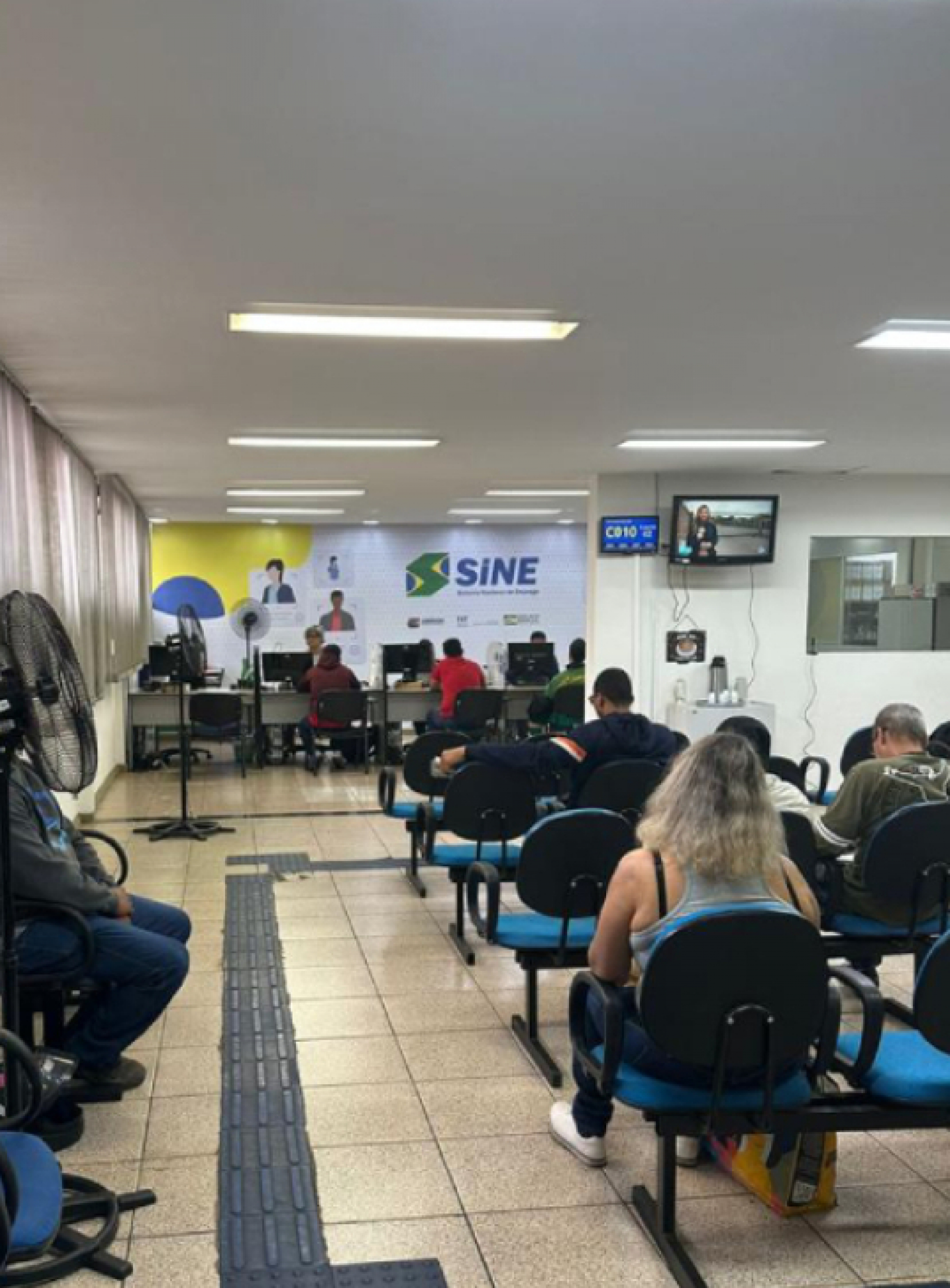 Pessoas aguardam atendimento em uma unidade do SINE para serviços relacionados ao emprego.