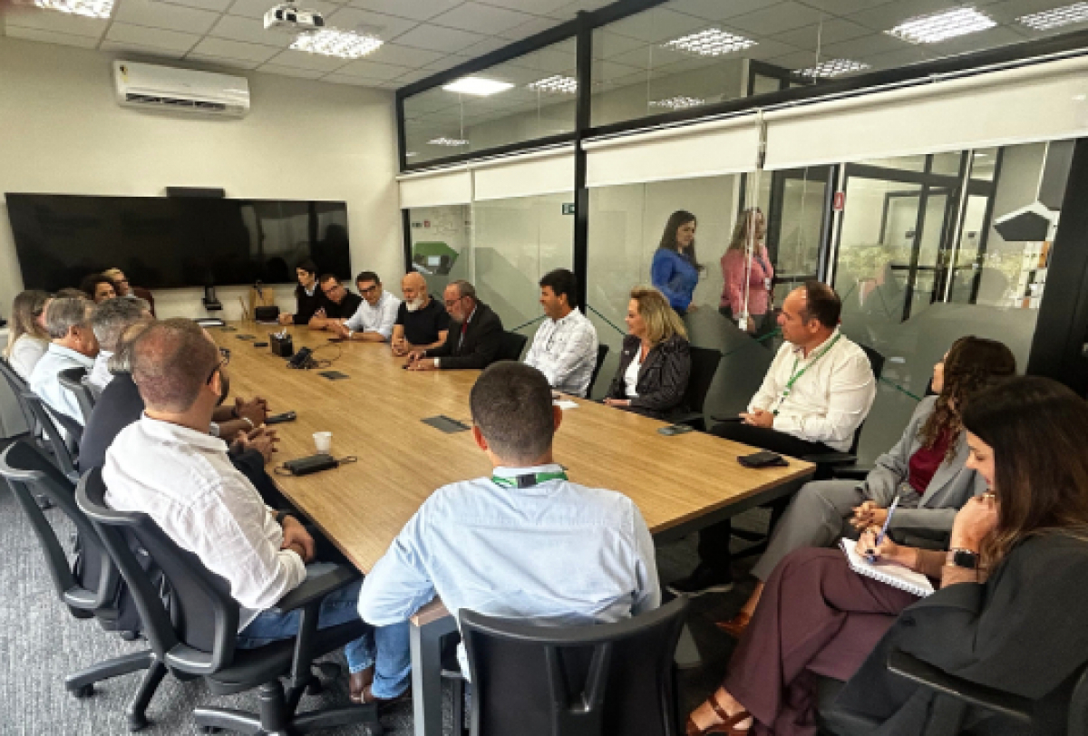 Reunião com diversos profissionais em uma sala corporativa, demonstrando um ambiente de discussão e planejamento estratégico.