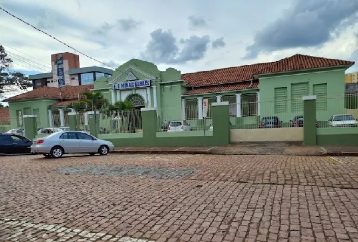 Fachada da escola estadual Minas Gerais, em prédio de arquitetura clássica e pintado de verde.